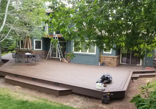 A deck being built in the backyard of a house.